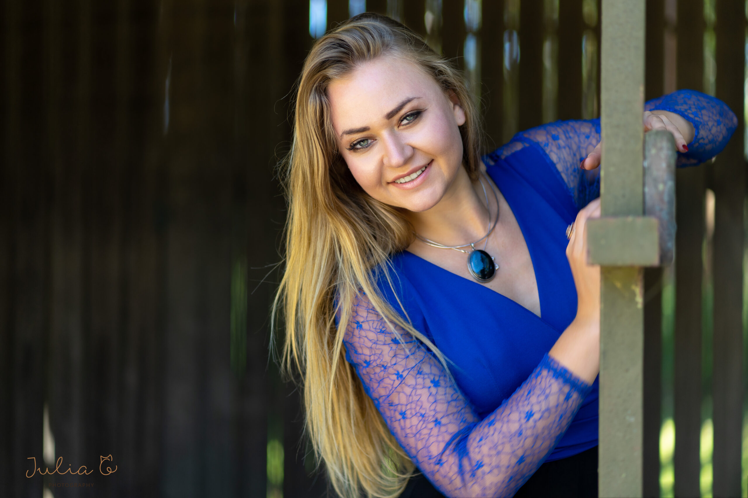 Blondie girl in blue dress looking at camera